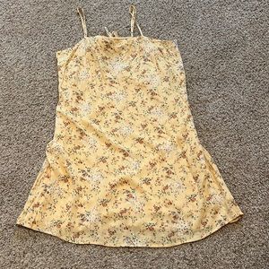 Yellow dress with red orange flowers and green leafing, bow tied, and zipper